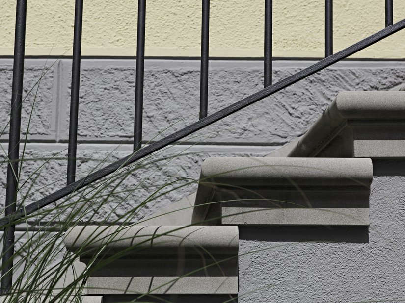 Dettaglio di una scala e del passaggio cromatico tra zoccolo e superficie della facciata.
