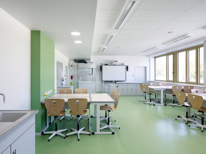 Le tonalità azzurro, turchese, verde e verde giallastro sono riproposte nei pavimenti gommati delle aule e degli uffici amministrativi.
