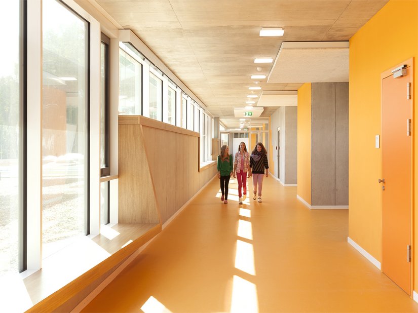I corridoi che portano alle aule, grazie alle finestre a nastro in legno, invitano a trattenersi.