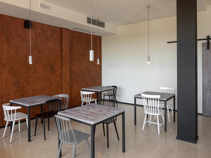 Il cuore della pizzeria è il grande forno in pietra rivestito di piastrelle effetto ruggine; la parete ha voluto riproporre lo stesso elemento decorativo.
