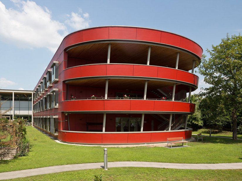 L’arca troneggia sul verde del parco circostante grazie alla sua tonalità intensa (RAL 3013 rosso pomodoro)&nbsp;.