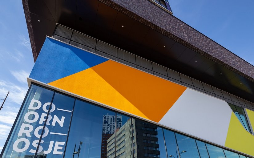 La scelta dei colori si ispira all'arcobaleno LGBTQ+, simbolo di quei valori di diversità, libertà e accettazione che il "Doornrosje" incarna dal 1968