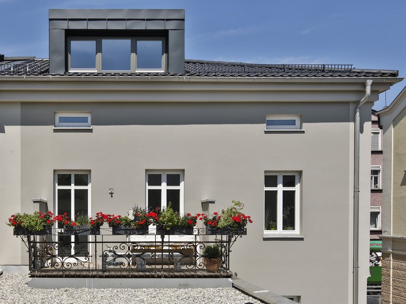 La facciata chiara si armonizza alla perfezione con il colore scuro del tetto.