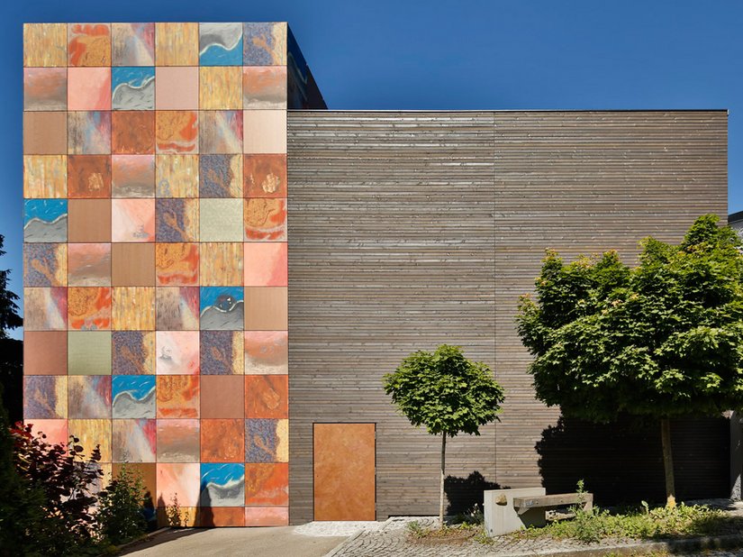 Con la facciata stravagante della sua torre, realizzata con coloratissimi pannelli Alucobond in calde tonalità rosse, marroni e blu che integrano ritratti di artisti, l'edificio emana un fascino straordinario.