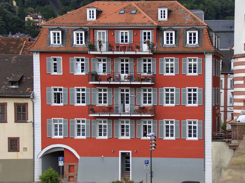 Il rosso e il grigio dominano la facciata del vecchio edificio scolastico.