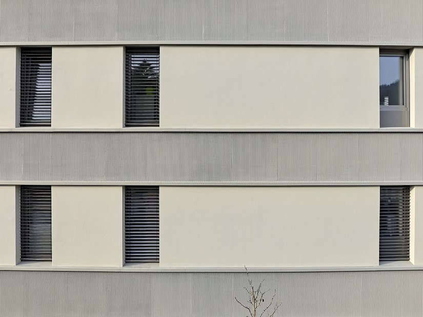 Piastrelle verticali e nastri per intonaco strutturati con tecnica a pettine in intonaco leggero minerale G 3679 creano una decorazione della facciata che unisce perfettamente vecchio e nuovo