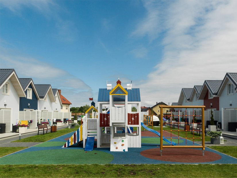 Il parco giochi tra le villette in legno offre uno spazio per il tempo libero.